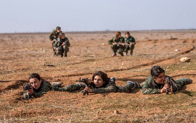 A female fighter of the Kurdish People's Protection Units (YPG) fires a Rocket-propelled grenade (RPG) as she participates in a military training