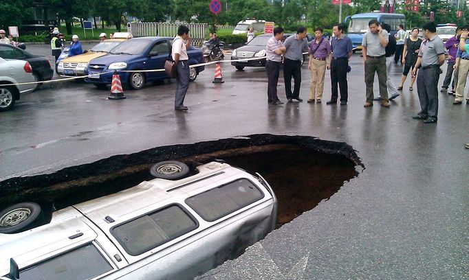 Van swallowed by sinkhole in road, Guilin, Guangxi Province, China - 07 Jun 2012 2012-06-07 00:00:00 Mandatory Credit: Photo by Quirky China News / Rex Features (1733870a) The van lying in the sinkhole Van swallowed by sinkhole in road, Guilin, Guangxi Province, China - 07 Jun 2012 The van driving along Fuxing Road was seen suddenly disappearing along with the forming of a giant sinkhole. Luckily, the driver only had slight injuries. Experts said the cave-in is due to the Karst landform in the region. When there is rain, the rising water underground may wash away the soil, causing a cave-in. The local public infrastructure company has refilled the sinkhole with soil.