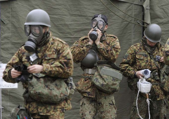 Japonští vojáci v prefektuře Fukušima si nasazují plynové masky.