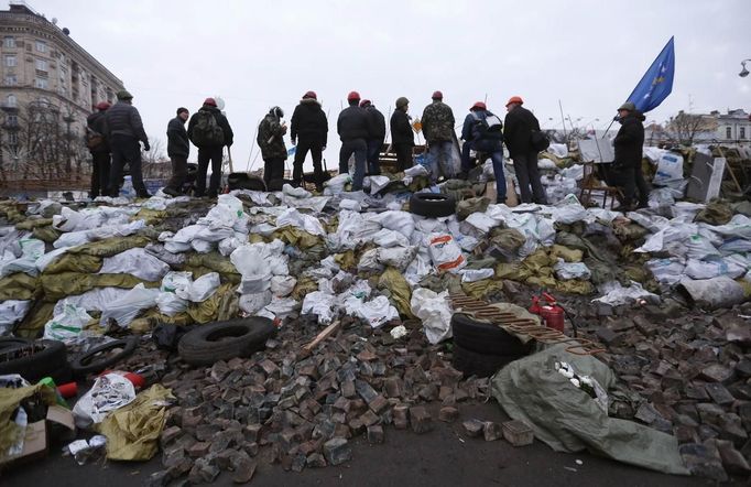 Anti-government protesters look out from a barricade in Kiev February 21, 2014.