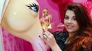 This picture taken on April 12, 2013 shows an employee posing with a barbie doll during a press presentation of the 'Barbie Dreamhouse in Berlin. The opening in May 2013 of the first life-sized Barbie Dreamhouse in Europe may be many little girls' fantasy, but Berlin feminists are mobilising against what they call a sexist icon.