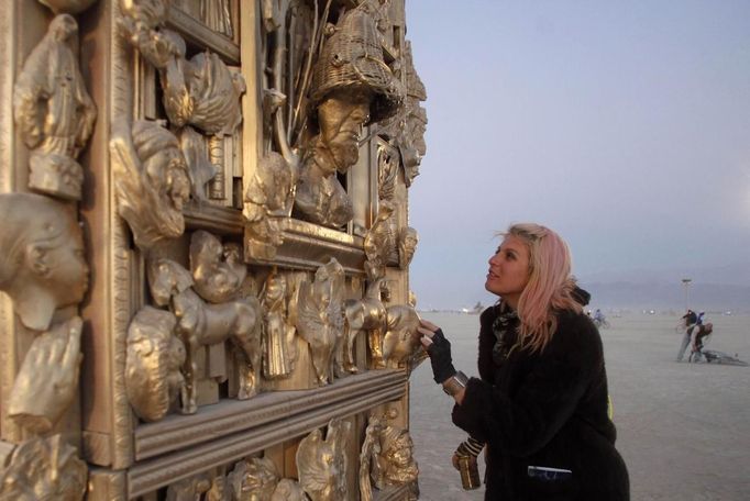 Ruth Kidd explores the art piece "Ego" before sunrise during the Burning Man 2012 "Fertility 2.0" arts and music festival in the Black Rock Desert of Nevada, August 29, 2012. More than 60,000 people from all over the world have gathered at the sold out festival, which is celebrating its 26th year, to spend a week in the remote desert cut off from much of the outside world to experience art, music and the unique community that develops.