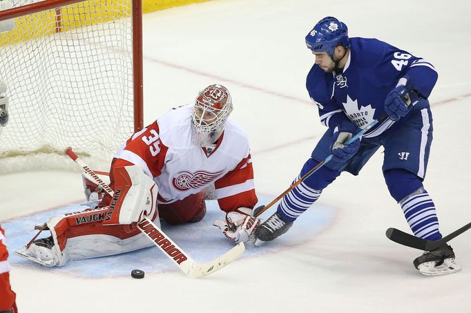 Oct 17, 2014; Toronto, Ontario, CAN; Detroit Red Wings goalie Jimmy Howard (35) stops a shot by Toronto Maple Leafs defenseman Roman Polak (46) at Air Canada Centre. The