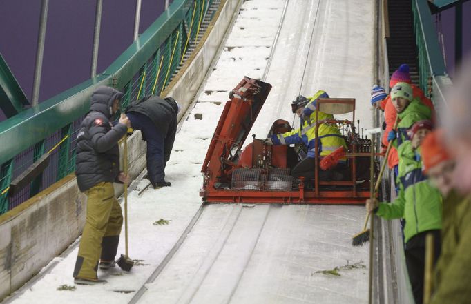 Officials and coaches work hard to freeze the in-run track of the ski jump slope ahead of a ski jumping competition at the FIS World Cup Ruka Nordic 2015 event in Kuusa