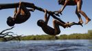 Yawalapiti children play over the Xingu River in the Xingu National Park, Mato Grosso State, May 9, 2012. In August the Yawalapiti tribe will hold the Quarup, which is a ritual held over several days to honour in death a person of great importance to them. This year the Quarup will be honouring two people - a Yawalapiti Indian who they consider a great leader, and Darcy Ribeiro, a well-known author, anthropologist and politician known for focusing on the relationship between native peoples and education in Brazil. Picture taken May 9, 2012. REUTERS/Ueslei Marcelino (BRAZIL - Tags: SOCIETY ENVIRONMENT) ATTENTION EDITORS - PICTURE 06 OF 28 FOR PACKAGE 'LIFE WITH THE YAWALAPITI TRIBE' Published: Kvě. 15, 2012, 5:09 odp.