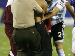 Venezuelská ochranka se snaží zastavit fanouška, který si chtěl sáhnout na Argentince Roberta Ayalu v zápase Copy Ameriky proti USA.