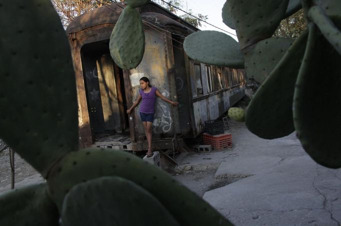 : Ruth stands outside a train carriage she calls home in Cadereyta on the outskirts of Monterrey August 8, 2012. Ruth, her eight other family members and their pets have been living in the abandoned carriage next to a set of train tracks for the last 15 years. Ruth's grandparents moved from Tamaulipas to Cadereyta after one of their sons was killed on the street by a stray bullet. The family moved into the wagon, which was empty after having been occupied by a vagabond, after living for the first five years in a rented room after arriving in Cadereyta. Picture taken August 8, 2012. REUTERS/Daniel Becerril (MEXICO - Tags: SOCIETY) Published: Srp. 11, 2012, 1:48 dop.