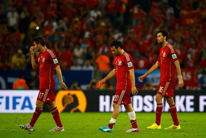 (L-R) Spain's Koke, Santi Cazorla and Sergio Busquets walk off the pitch at the end of their 2014 World Cup Group B soccer match against Chile at the Maracana stadium in