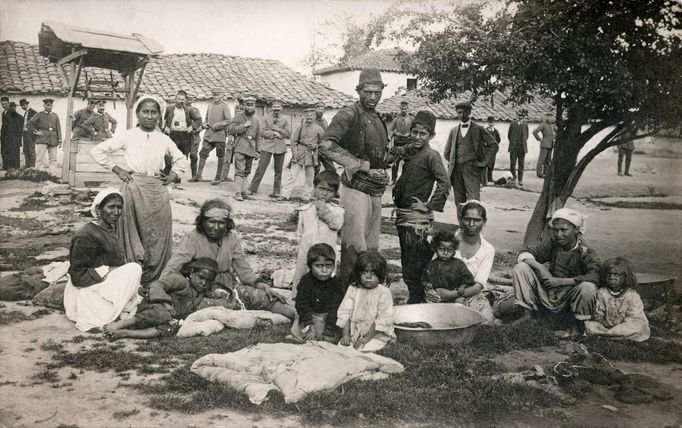 Romští osadníci se svými ratolestmi a němečtí vojáci stojící v pozadí. Rok 1915-18.