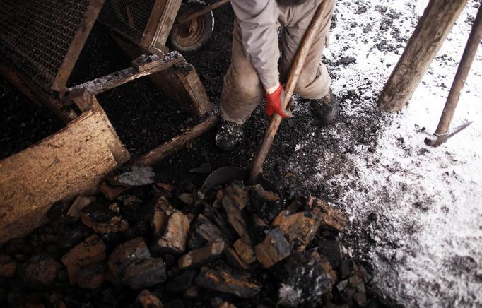 An illegal miner shovels coal in the village of Stranjani, near Zenica, December 11, 2012. There are about 20 illegal mines in the area, where Bosnians dig for coal with their bare hands and use makeshift tools, such as bathtubs, to transport the coal. One bag of their coal is sold for 3 euros ($4 dollars), which is popular with the locals as it is cheaper than the coal sold at the city mine. REUTERS/Dado Ruvic (BOSNIA AND HERZEGOVINA - Tags: BUSINESS ENERGY CRIME LAW SOCIETY) BOSNIA AND HERZEGOVINA OUT. NO COMMERCIAL OR EDITORIAL SALES IN BOSNIA AND HERZEGOVINA Published: Pro. 11, 2012, 4:31 odp.