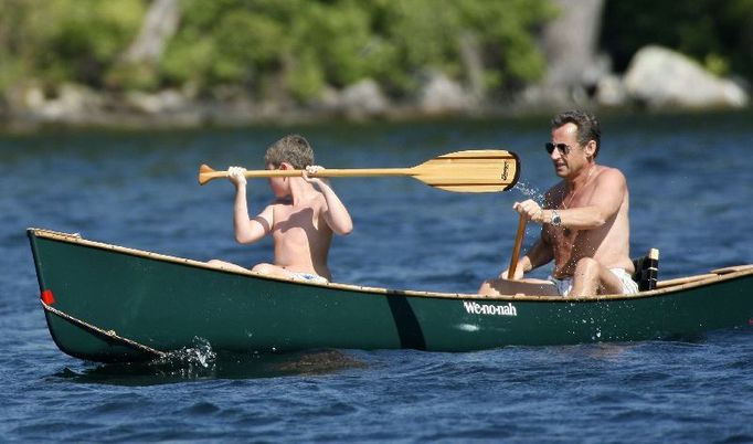 France's President Nicolas Sarkozy paddles a canoe with his son Louis on Lake Winnipesaukee while on vacation in Wolfeboro, New Hampshire August 4, 2007. REUTERS / Neal Hamberg (UNITED STATES)