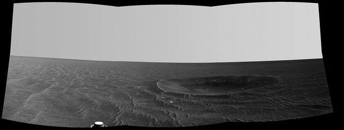 'Yankee Clipper' Crater on Mars (Left Eye) "Yankee Clipper" crater on Mars carries the name of the command and service module of NASA's 1969 Apollo 12 mission to the moon. NASA's Mars Exploration Rover Opportunity recorded this stereo view of the crater during a pause in a 102-meter (365-foot) drive during the 2,410th Martian day, or sol, of the rover's work on Mars (Nov. 4, 2010). This view is a mosaic of three frames taken by the left eye of Opportunity's navigation camera. Yankee Clipper crater is about 10 meters (33 feet) in diameter. The rover science team uses a convention of assigning the names of historic ships of exploration as the informal names for craters seen by Opportunity. Apollo 12's Yankee Clipper orbited Earth's moon while the mission's lunar module carried two astronauts to the lunar surface on Nov. 19, 1969, and later brought all three of the mission's astronauts back to Earth, arriving Nov. 24, 1969. A dramatic view of Earth rising over a lunar horizon, taken from Apollo 12's Yankee Clipper, is online at http://spaceflight.nasa.gov/gallery/images/apollo/apollo12/html/as12-47-6891.html. Image Credit: NASA/JPL-Caltech