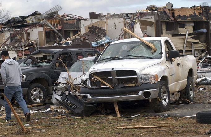 Muž míjí zdevastované automobily. Jackson, Tennessee