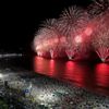 People gather to watch fireworks explode over Copacabana beach during New Year celebrations in Rio de Janeiro