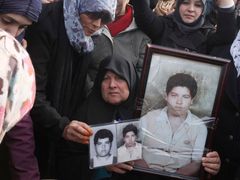 Žena ukazuje snímky svého syna. Během předchozích dnů přišel při protestech v Benghází o život.