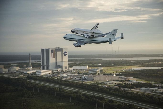 The space shuttle Endeavour, atop NASA's Shuttle Carrier Aircraft, flies over the Kennedy Space Center in Cape Canaveral, Florida in this September 19, 2012 NASA handout photo. The SCA, a modified 747 jetliner is flying Endeavour to Los Angeles where it will be placed on public display at the California Science Center. This is the final ferry flight scheduled in the Space Shuttle Program era. REUTERS/Robert Markowitz/NASA/Handout. (UNITED STATES - Tags: SCIENCE TECHNOLOGY TRANSPORT) THIS IMAGE HAS BEEN SUPPLIED BY A THIRD PARTY. IT IS DISTRIBUTED, EXACTLY AS RECEIVED BY REUTERS, AS A SERVICE TO CLIENTS. FOR EDITORIAL USE ONLY. NOT FOR SALE FOR MARKETING OR ADVERTISING CAMPAIGNS Published: Zář. 20, 2012, 1:51 dop.