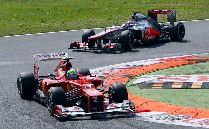 Brazilský jezdec F1 Felipe Massa ujíždí před Britem Jensonem Buttonem ve Velké ceně Itálie.