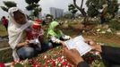 A family reads verses from the Koran at a relative's grave in a cemetery, a day before the Islamic holy month of Ramadan, in Jakarta July 9, 2013. Traditionally Indonesian Muslims will visit the graves of their relatives before and towards the end of the the holy month. REUTERS/Enny Nuraheni (INDONESIA - Tags: RELIGION SOCIETY) Published: Čec. 9, 2013, 8:57 dop.