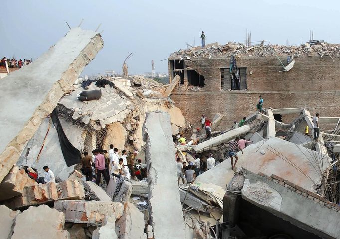 Rescue workers look for trapped garment workers in the Rana Plaza building which collapsed, in Savar, 30 km (19 miles) outside Dhaka April 24, 2013. A block housing garment factories and shops collapsed in Bangladesh on Wednesday, killing nearly 100 people and injuring more than a thousand, officials said.REUTERS/Andrew Biraj (BANGLADESH - Tags: DISASTER BUSINESS TPX IMAGES OF THE DAY) Published: Dub. 24, 2013, 5:10 odp.