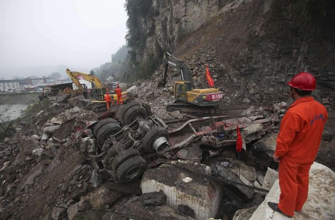 A rescuer looks on as excavators clean up a road which is blocked by a landslide after Saturday's earthquake, in Baoxing county, Sichuan province April 22, 2013. The death toll has risen to at least 188, with more than 11,000 others injured, after an earthquake struck in Lushan county, near the city of Ya'an in the southwestern province of Sichuan on Saturday, Xinhua News Agency reported. REUTERS/China Daily (CHINA - Tags: DISASTER TPX IMAGES OF THE DAY) CHINA OUT. NO COMMERCIAL OR EDITORIAL SALES IN CHINA Published: Dub. 22, 2013, 2:06 odp.