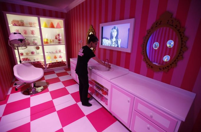 A staff poses for the photographer inside a life-size "Barbie Dreamhouse" of Mattel's barbie dolls in the bathroom during a media tour in Berlin, May 15, 2013. The life-sized house, covering about 1,400 square metres offers visitors to try on Barbie's clothes in her walk-in closet, tour her living room and her kitchen. REUTERS/Fabrizio Bensch (GERMANY - Tags: ENTERTAINMENT SOCIETY) Published: Kvě. 15, 2013, 2:46 odp.