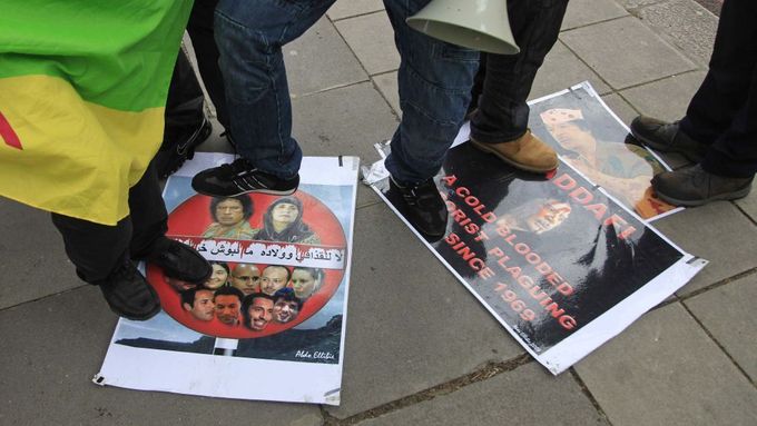 Skupina Libyjců šlape po plakátech s Kaddáfím a jeho rodinou při protestu před libyjským velvyslanectvím v Londýně.