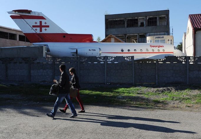 A picture taken on October 29, 2012, shows people walking past a Soviet-era Yakovlev Yak-42 plane turned into a kindergarten in the Georgian city of Rustavi, some 25 km southeast of the capital Tbilisi. Local head teacher Gari Chapidze bought the old but fully functional Yak-42 from Georgian Airways and refurbished its interior with educational equipment, games and toys but left the cockpit instruments intact so they could be used as play tools.