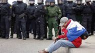 Demonstrant, protestující proti NATO, u kordonu policistů.