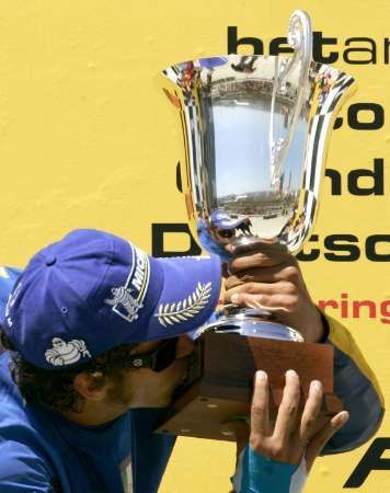 Jezdec Yamahy Valentino Rossi líbá trofej