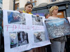 Uprchlice z Luhansku ukazují na demonstraci v Kyjevě, co se stalo s jejich domy.