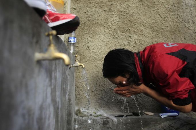 Marathon runner Gladys Tejeda, the first Peruvian athlete who qualified for the 2012 London Olympic Games, washes her face before training at her home in the Andean province of Junin May 15, 2012. A private company will take Gladys' mother Marcelina Pucuhuaranga, 69, to London as part of the "Thank you Mom" program. For Pucuhuaranga, who received her first passport, it will be the first time travelling out of Peru. The program will take about 120 mothers of different athletes around the world to attend the games. Tejeda, the youngest of nine children, returned to her hometown to visit her mother and to focus on training where she will run more than 20 km every day in the highlands (over 4,105 meters above sea level). Picture taken May 15, 2012. REUTERS/Pilar Olivares (PERU - Tags: SPORT ATHLETICS OLYMPICS) Published: Kvě. 17, 2012, 6:20 odp.