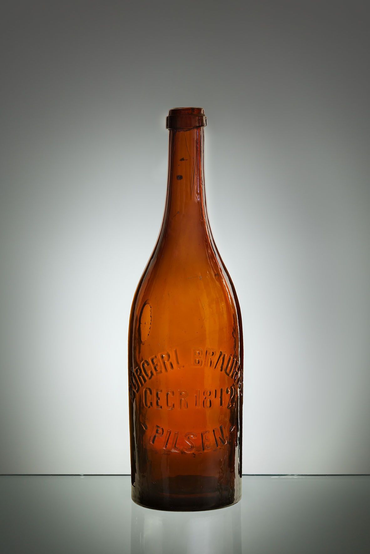 Pilsner Urquell skleněná lahev kolem roku 1900 s reliéfním nápisem