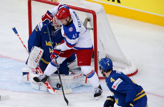 Sweden's goalie Anders Nilsson (L) saves in front of Russia's Nikolai Kulyomin in the first period of their men's ice hockey World Championship semi-final game at Minsk A