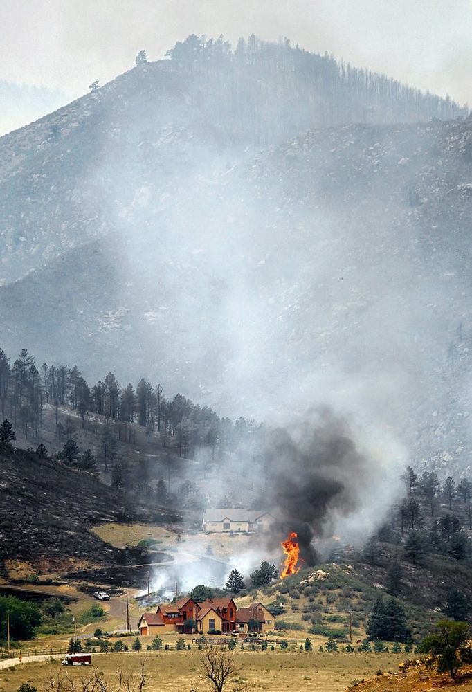 Smoke and flames encroach upon homes on the eastern front of the High Park fire near Laporte, Colorado June 10, 2012. A wind-driven wildfire burning in a rugged Colorado canyon spread out of control, forcing hundreds of people to evacuate and one person in the fire zone was reported missing, officials said on Sunday. REUTERS/Marc Piscotty (UNITED STATES - Tags: DISASTER ENVIRONMENT) Published: Čer. 10, 2012, 9:37 odp.