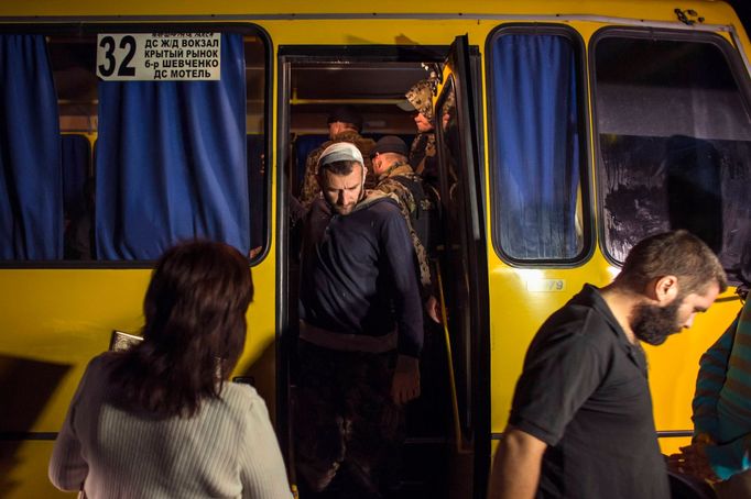 Členové ukrajinských vládních sil vystupují z autobusu před výměnou.Severně od Doněcku, východní Ukrajina, 12.9.2014