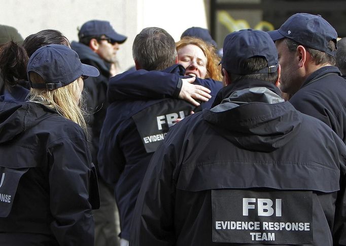 Officers embrace near the site of the explosion on Boylston Street after the FBI officially returned jurisdiction of the area over to the city in Boston, Massachusetts, April 22, 2013. REUTERS/Chitose Suzuki/Boston Herald/Pool (UNITED STATES - Tags: CRIME LAW DISASTER) Published: Dub. 22, 2013, 11:51 odp.