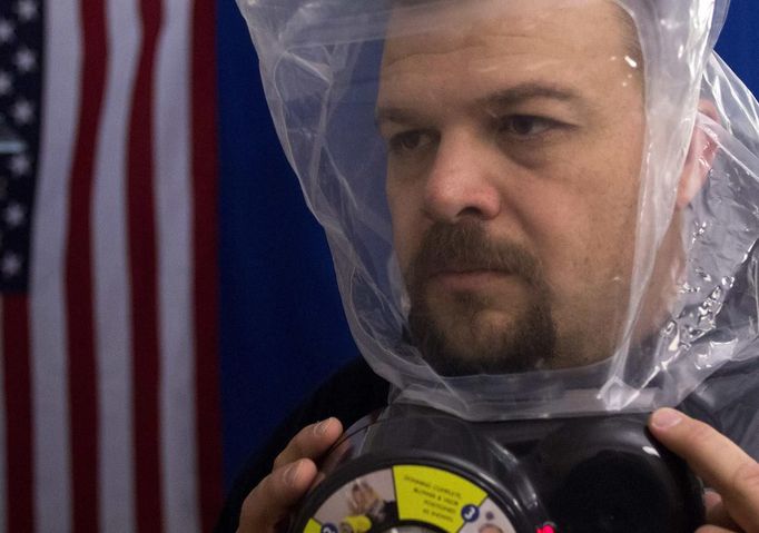 Phil Burns demonstrates the air purifying SCape Mask at his home in American Fork, Utah, December 14, 2012. While most "preppers" discount the Mayan calendar prophecy, many are preparing to be self-sufficient for threats like nuclear war, natural disaster, famine and economic collapse. Picture taken December 14, 2012. REUTERS/Jim Urquhart (UNITED STATES - Tags: SOCIETY) Published: Pro. 18, 2012, 5:23 odp.