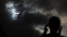 A tourist watches as the moon passing in front of the sun as it approaches a full solar eclipse in the northern Australian city of Cairns November 14, 2012. REUTERS/Tim Wimborne (AUSTRALIA - Tags: SOCIETY ENVIRONMENT) Published: Lis. 13, 2012, 9:39 odp.