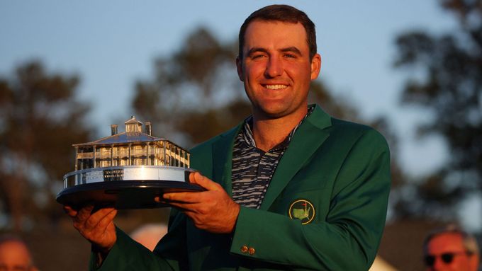 Scottie Scheffler v zeleném saku a s trofejí pro vítěze golfového Masters