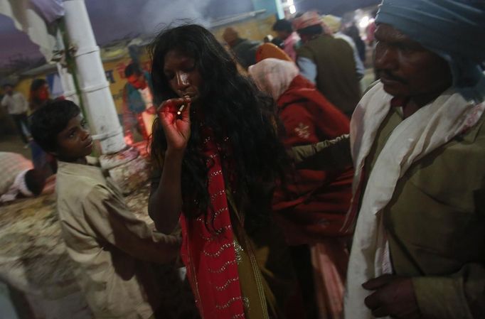 A devotee who is believed to be possessed by evil spirits smokes a bidi as she walks around the courtyard of Guru Deoji Maharaj temple during a ghost fair at Malajpur village in Betul district in the central Indian state of Madhya Pradesh January 27, 2013. People from across India come to this fair to be exorcised of �evil spirits�. They are usually brought by relatives and they are most often women. The exorcism involves running around the temple courtyard to make the 'ghost' weak then being beaten by a priest with a broom. Picture taken January 27, 2013. REUTERS/Danish Siddiqui (INDIA - Tags: SOCIETY RELIGION) ATTENTION EDITORS: PICTURE 24 OF 24 FOR PACKAGE 'INDIAN GHOSTBUSTERS' SEARCH 'INDIA GHOST' FOR ALL IMAGES Published: Úno. 5, 2013, 5:10 dop.