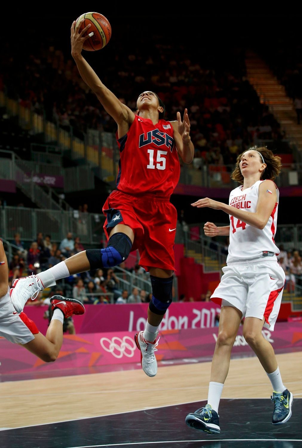 Česká basketbalistka Tereza Pecková pronásleduje smečující Američanku Candace Parkerovou v utkání skupiny A na OH 2012 v Londýně.