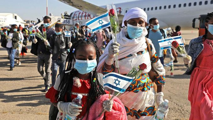 Etiopští židovští přistěhovalci mávají izraelskými vlajkami na letišti Ben Gurion v Lodu, východně od Tel Avivu, 21. května 2020.