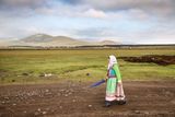 Tatjana Oslapova vyšňořená ve slavnostním kroji se vrací domů z nedělní ranní bohoslužby. Krajina kolem Gorelovky připomíná náhorní planiny v Tibetu.
