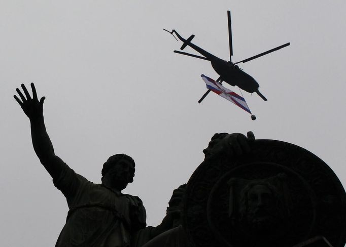 A Russian service helicopter carrying a military insignia flies over a monument on Red Square during the Victory Parade in Moscow May 9, 2012. Russia celebrates the 67th anniversary of the victory over Nazi Germany on Wednesday. REUTERS/Maxim Shemetov (RUSSIA - Tags: MILITARY ANNIVERSARY SOCIETY) Published: Kvě. 9, 2012, 9:16 dop.