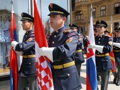 Čestná stráž nese vlajky států, jejichž prezidenti přijeli na 14. summit do Brna.