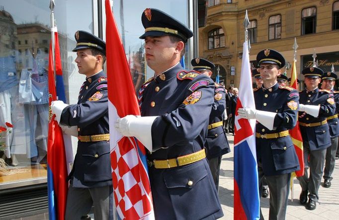 Čestná stráž nese vlajky států, jejichž prezidenti přijeli na 14. summit do Brna.