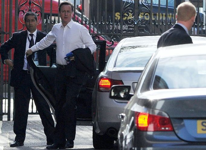 Blíží se čtvrtá odpoledne. Cameron schůzkuje, telefonuje, zde ho fotograf zastihl, jak vystupuje - kravatu v ruce - před Portcullis House. Vzápětí Cameronovi vyjednavači oznamují, že se s liberály dohodli na obrysech předběžné koaliční smlouvy.