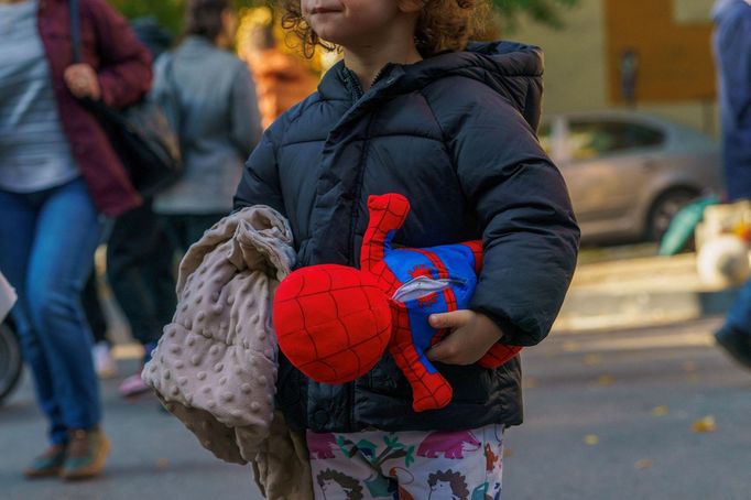 Chlapec drží plyšovou hračku Spider-Mana poblíž místa výbuchu v bytovém domě v Bukurešti, Rumunsko, 17. října 2025.