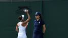 Tennis - Wimbledon - All England Lawn Tennis and Croquet Club, London, Britain - July 3, 2019  Romania's Mihaela Buzarnescu passes up a bottle of water to a spectator who