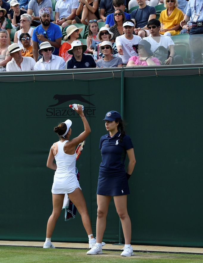 Tennis - Wimbledon - All England Lawn Tennis and Croquet Club, London, Britain - July 3, 2019  Romania's Mihaela Buzarnescu passes up a bottle of water to a spectator who